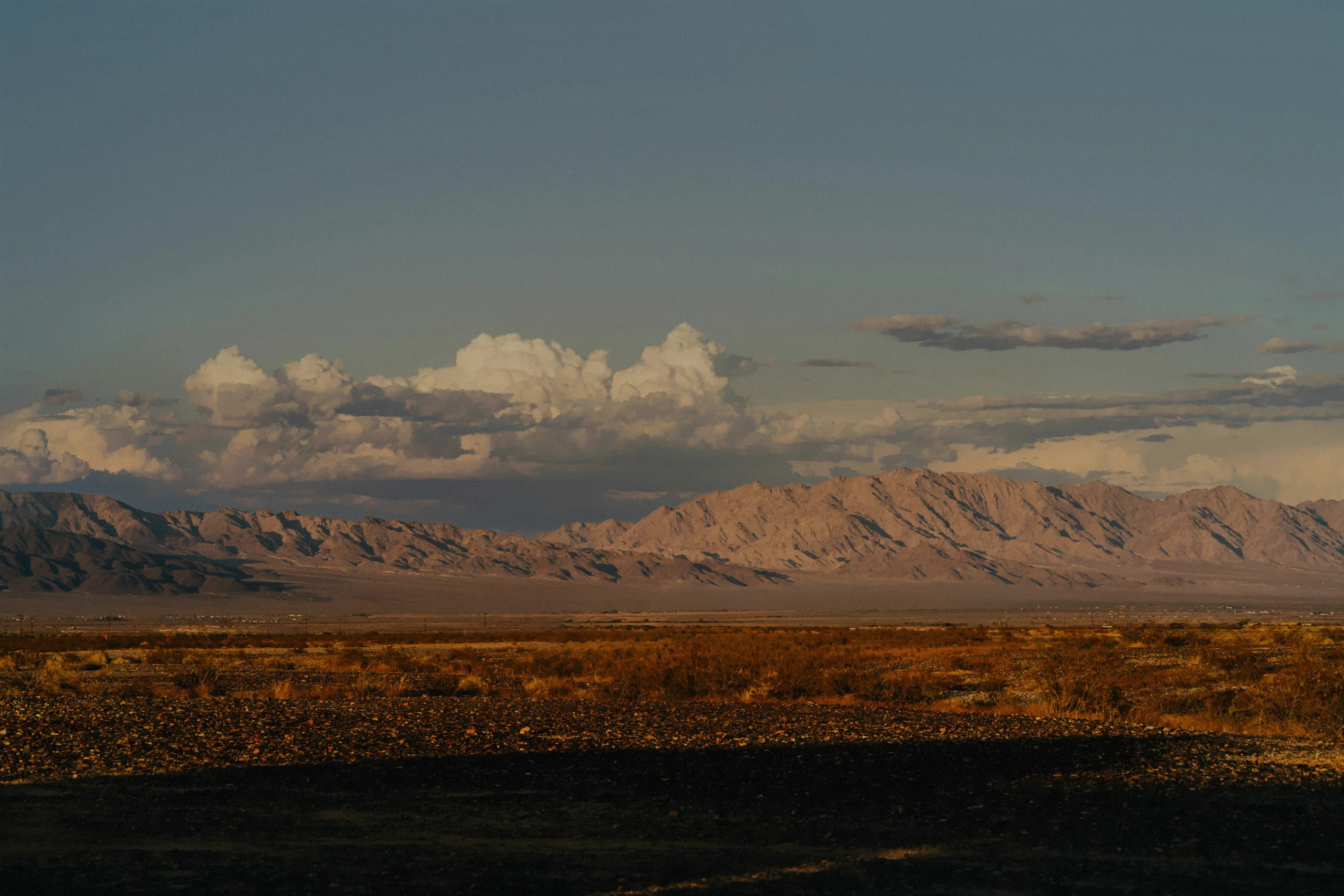 A mountain range beyond an open desert plain